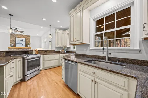 a kitchen with kitchen island granite countertop a sink cabinets and stainless steel appliances