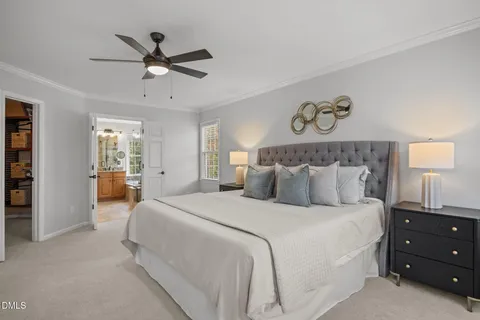 a bedroom with a large bed and a chandelier