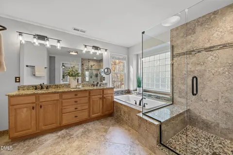 a spacious bathroom with a shower a sink and a mirror