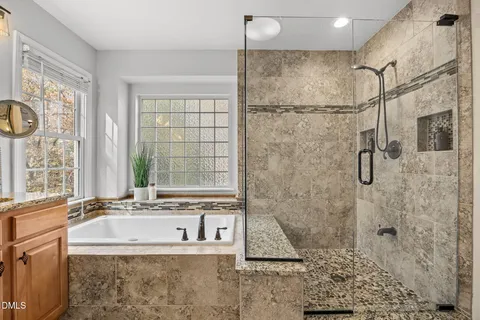 a bathroom with a granite countertop shower a sink and a large mirror