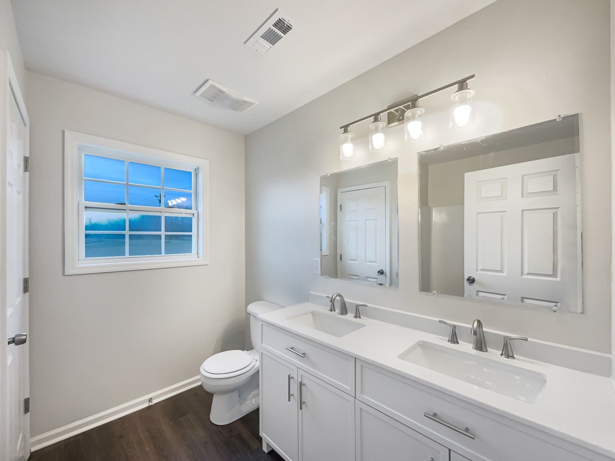 6180 Hoover Road Lascassas, TN 37085 - Photo 17 of 22 a bathroom with a toilet a sink a mirror and a window