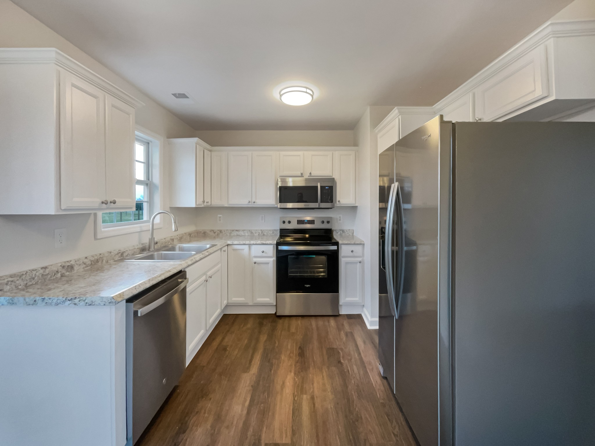 6180 Hoover Road Lascassas, TN 37085 - Photo 6 of 22 a kitchen with a refrigerator a sink and dishwasher a oven with wooden floor
