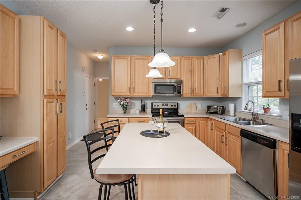 16616 Timber Crossing Road Charlotte, NC 28213 - Photo 21 of 40 a kitchen with stainless steel appliances a table chairs sink refrigerator and microwave