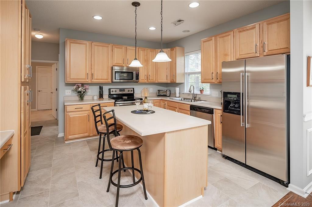 16616 Timber Crossing Road Charlotte, NC 28213 - Photo 22 of 40 a kitchen with stainless steel appliances granite countertop a refrigerator a sink dishwasher a stove and a refrigerator with wooden floor