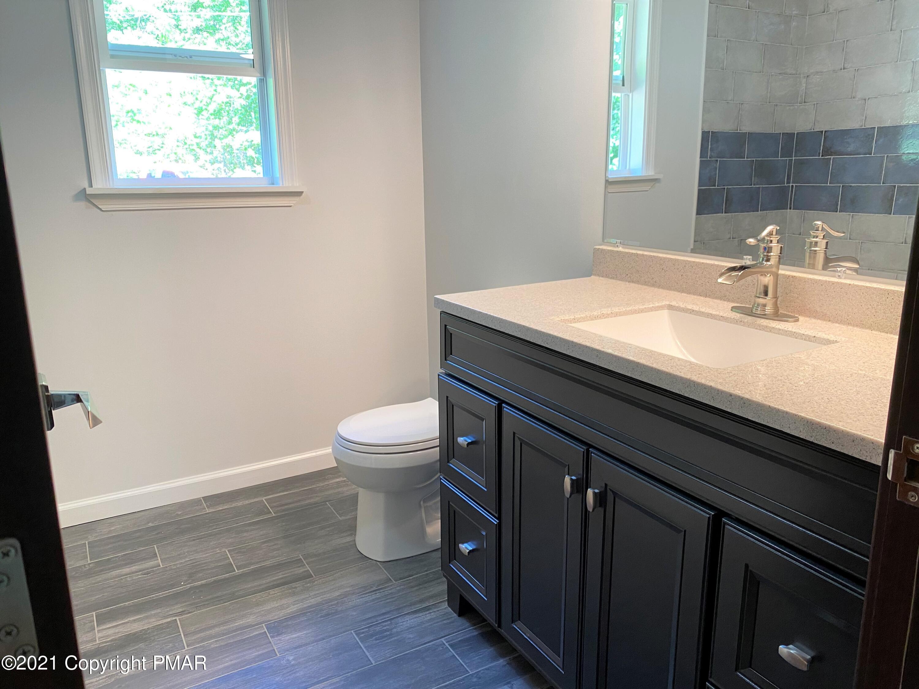 143 Britt Court Cresco, PA 18326 - Photo 17 of 35 a bathroom with a granite countertop toilet sink and mirror