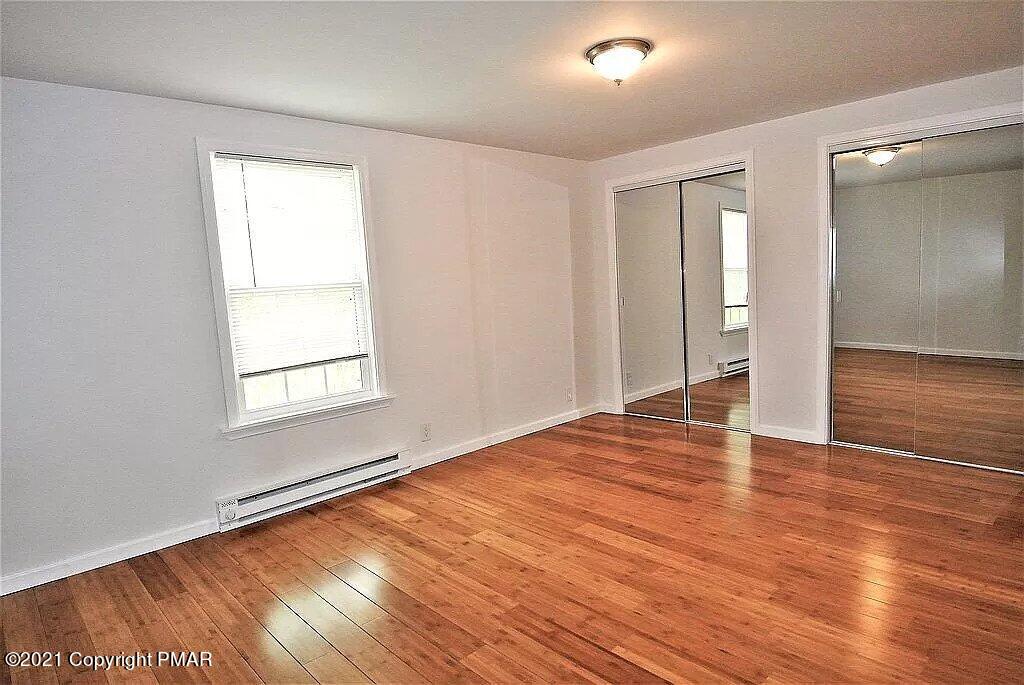 143 Britt Court Cresco, PA 18326 - Photo 19 of 35 an empty room with wooden floor and windows