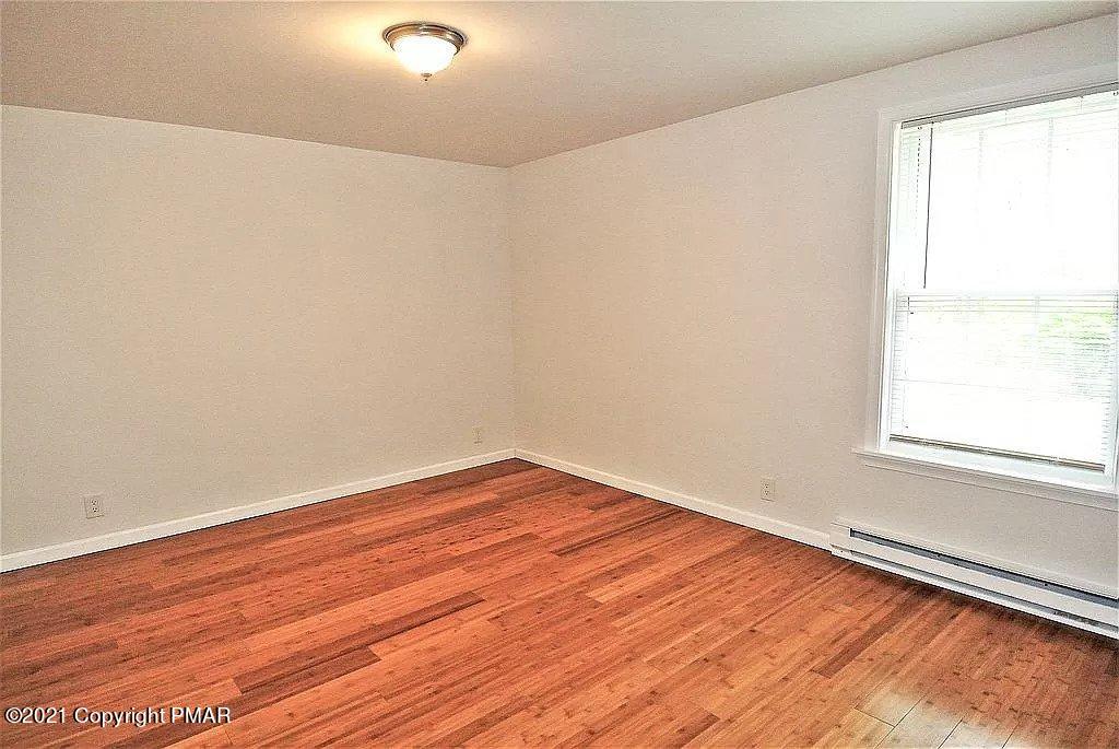 143 Britt Court Cresco, PA 18326 - Photo 20 of 35 an empty room with wooden floor and windows