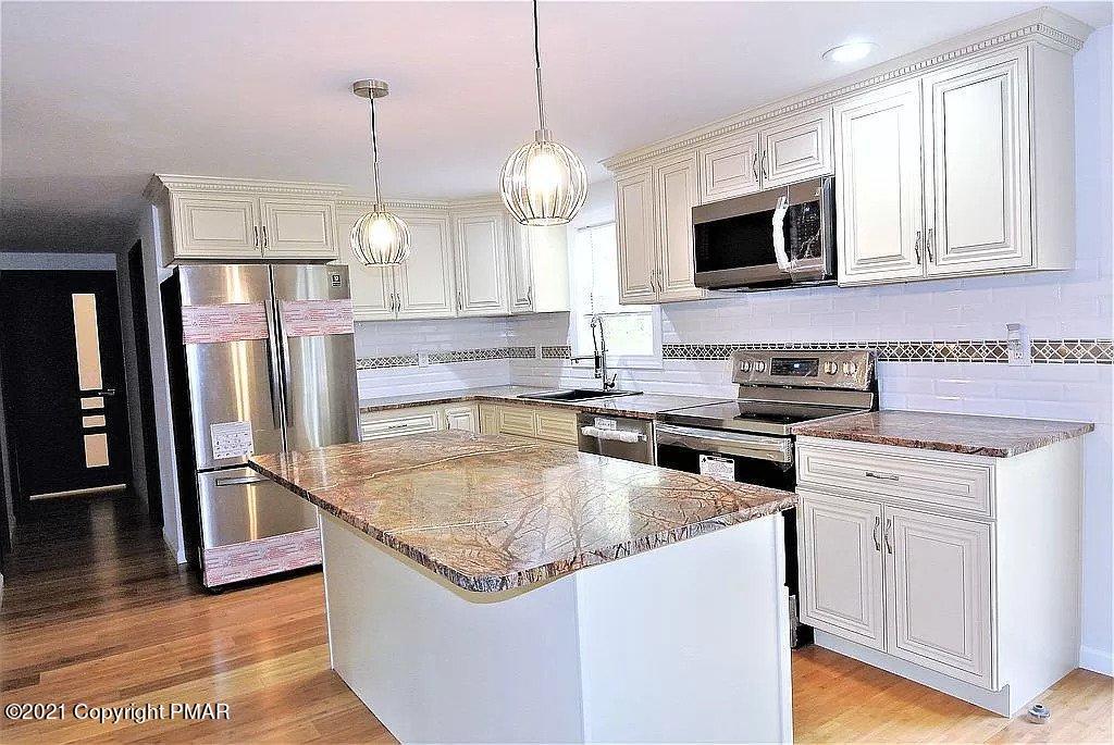 143 Britt Court Cresco, PA 18326 - Photo 2 of 35 a kitchen with stainless steel appliances granite countertop a sink a stove a microwave a refrigerator a counter space and cabinets