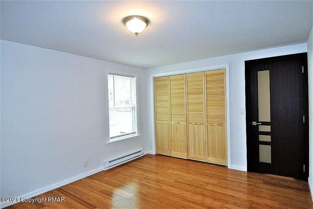 143 Britt Court Cresco, PA 18326 - Photo 21 of 35 an empty room with wooden floor and windows