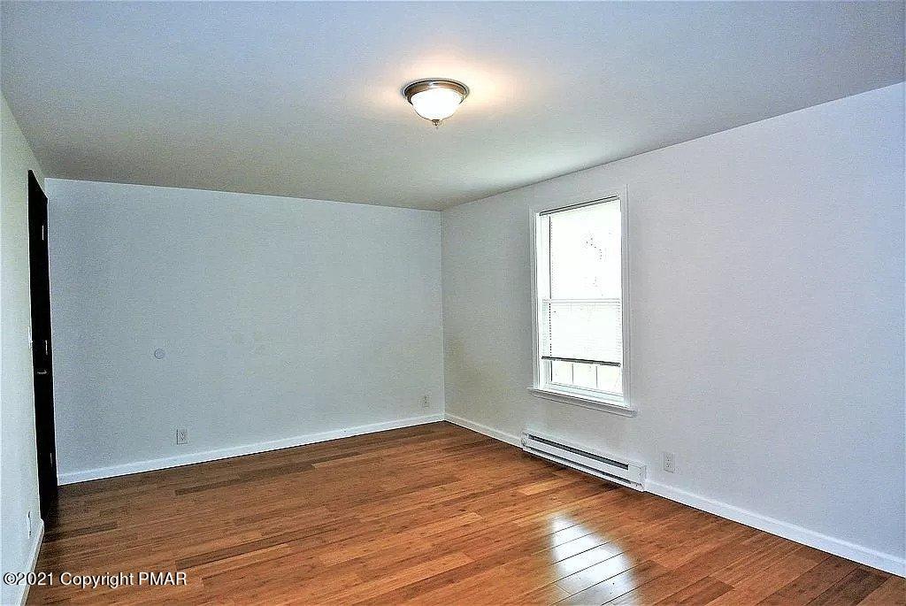 143 Britt Court Cresco, PA 18326 - Photo 22 of 35 an empty room with wooden floor and windows
