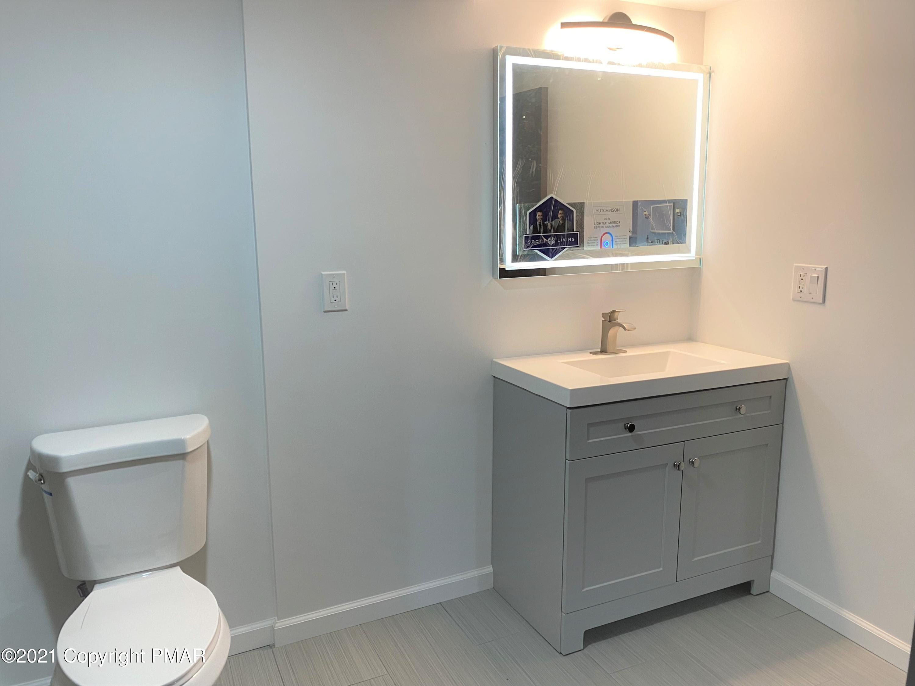 143 Britt Court Cresco, PA 18326 - Photo 27 of 35 a bathroom with a toilet sink and mirror