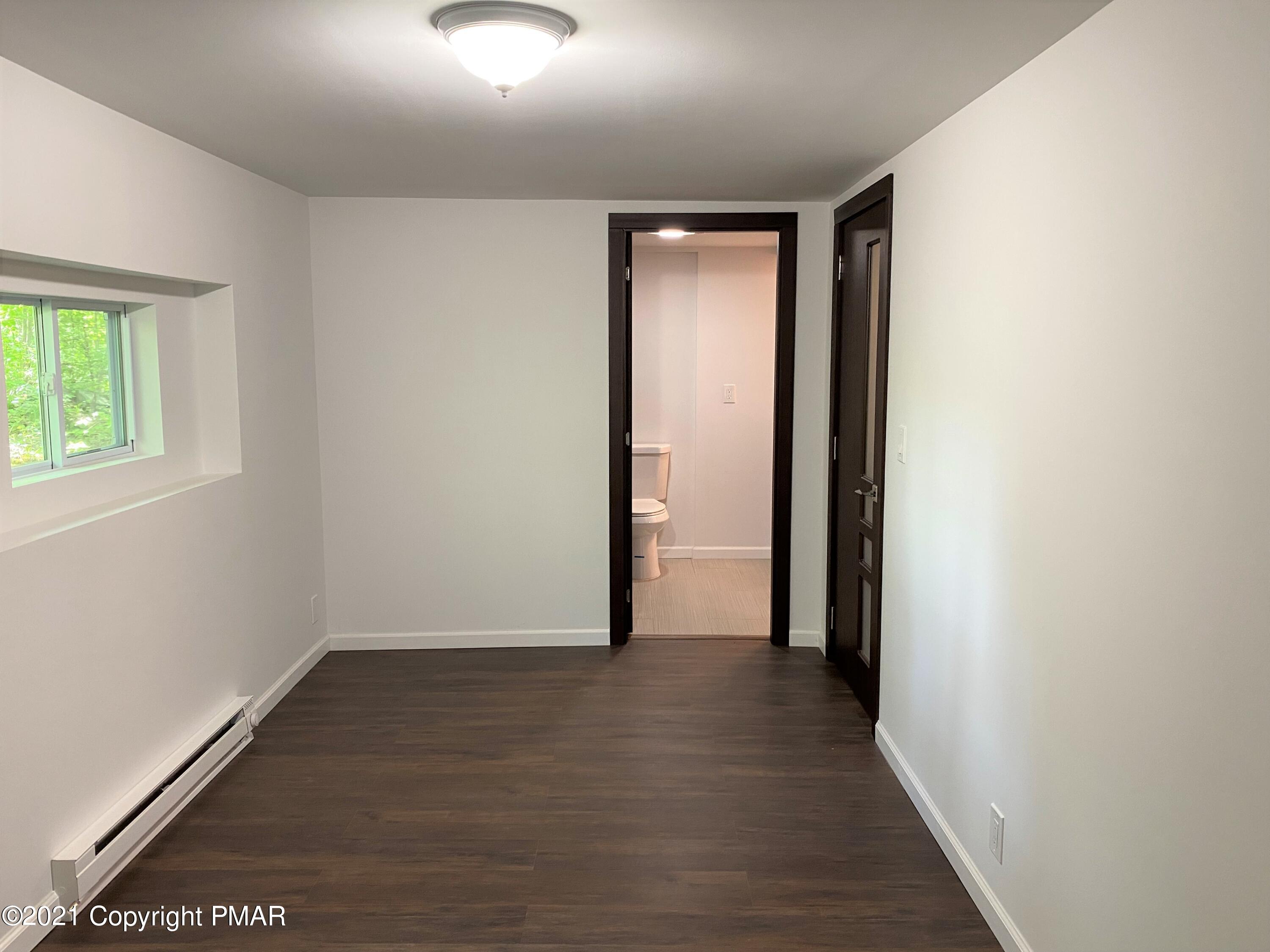 143 Britt Court Cresco, PA 18326 - Photo 30 of 35 an empty room with wooden floor and windows