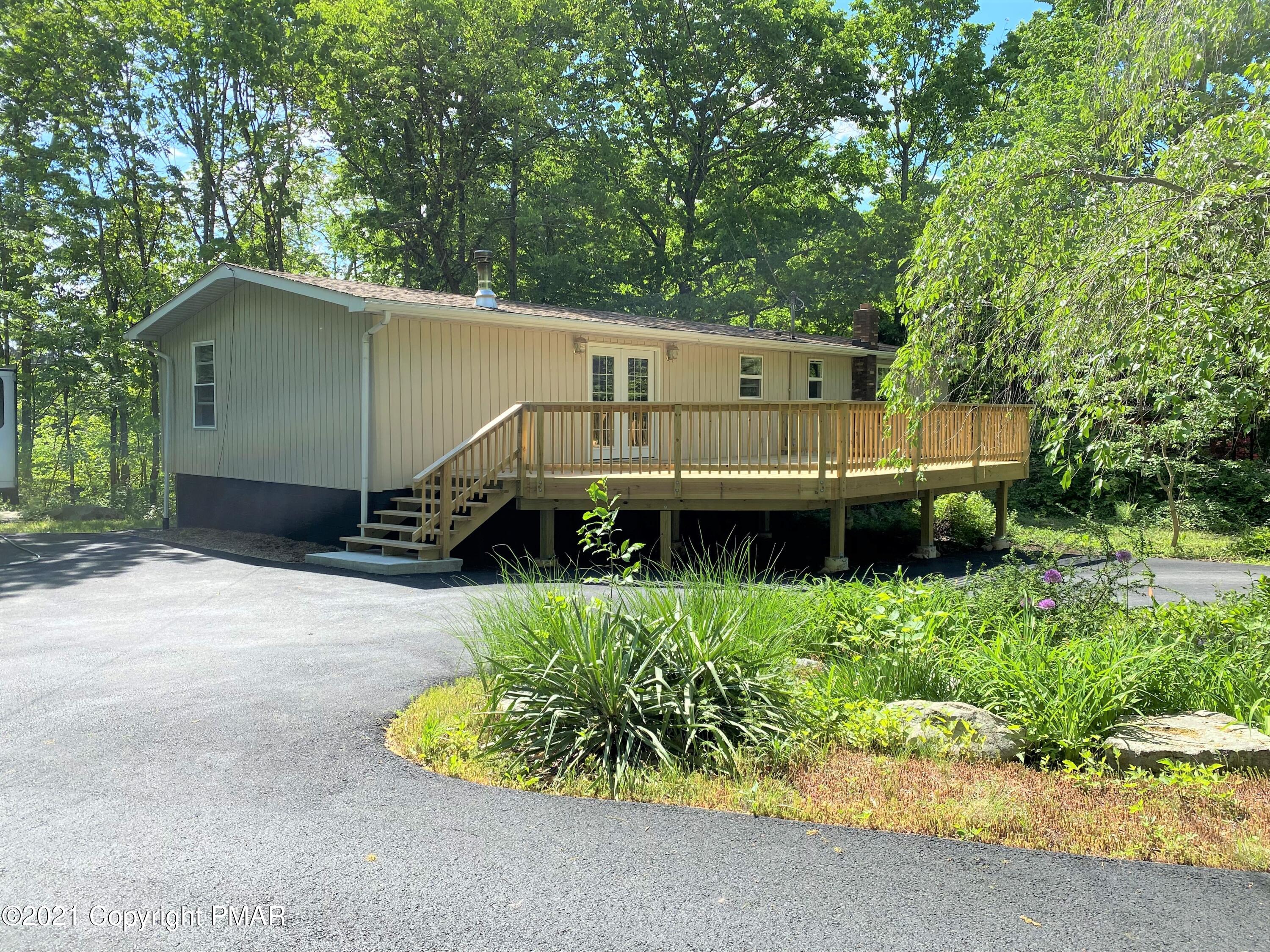 143 Britt Court Cresco, PA 18326 - Photo 33 of 35 a view of a small house with a yard plants and large tree