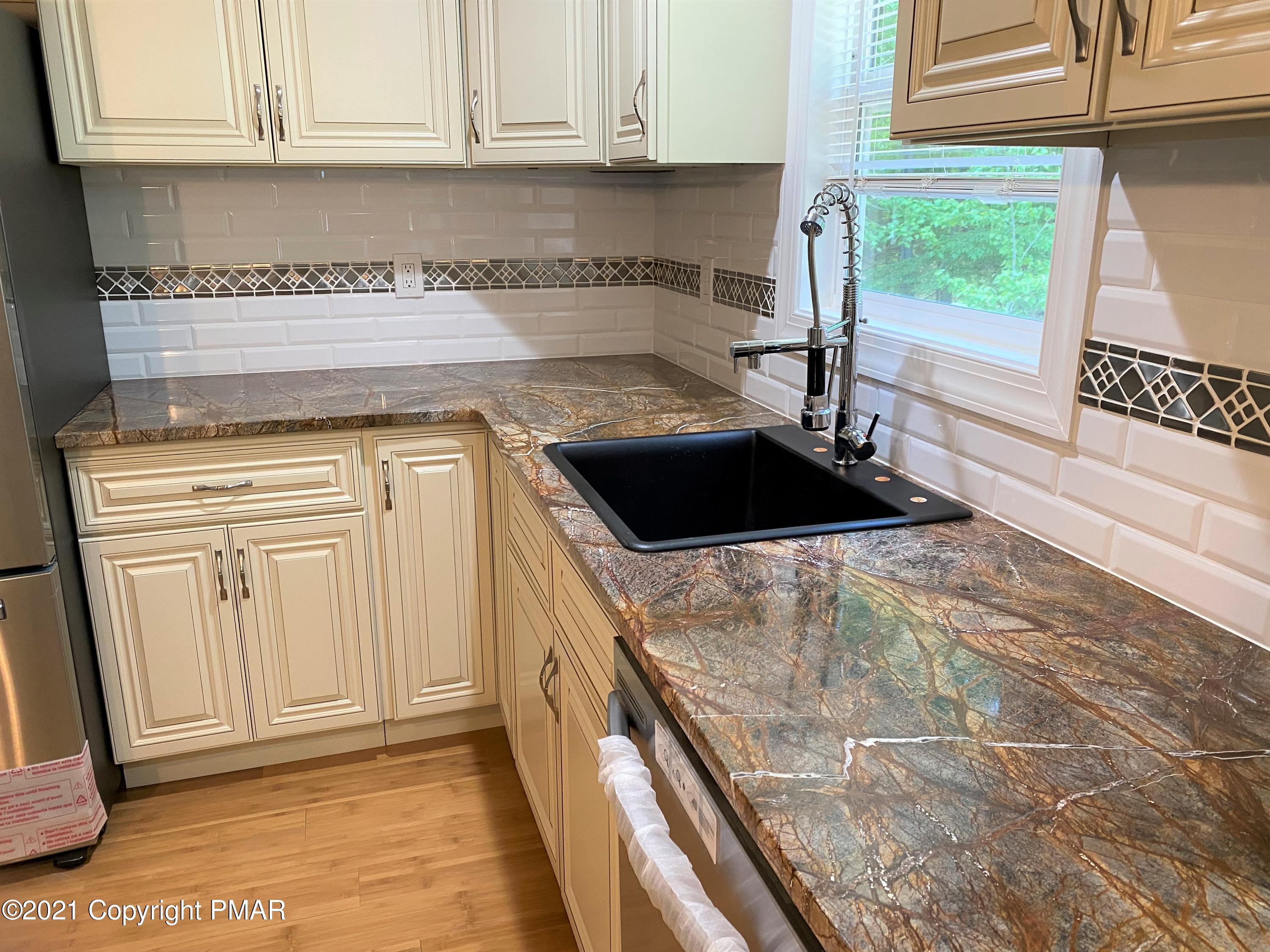 143 Britt Court Cresco, PA 18326 - Photo 5 of 35 a kitchen with white cabinets and a window