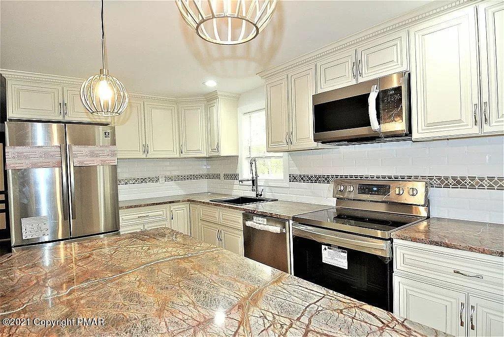 143 Britt Court Cresco, PA 18326 - Photo 9 of 35 a kitchen with stainless steel appliances a stove microwave and a refrigerator