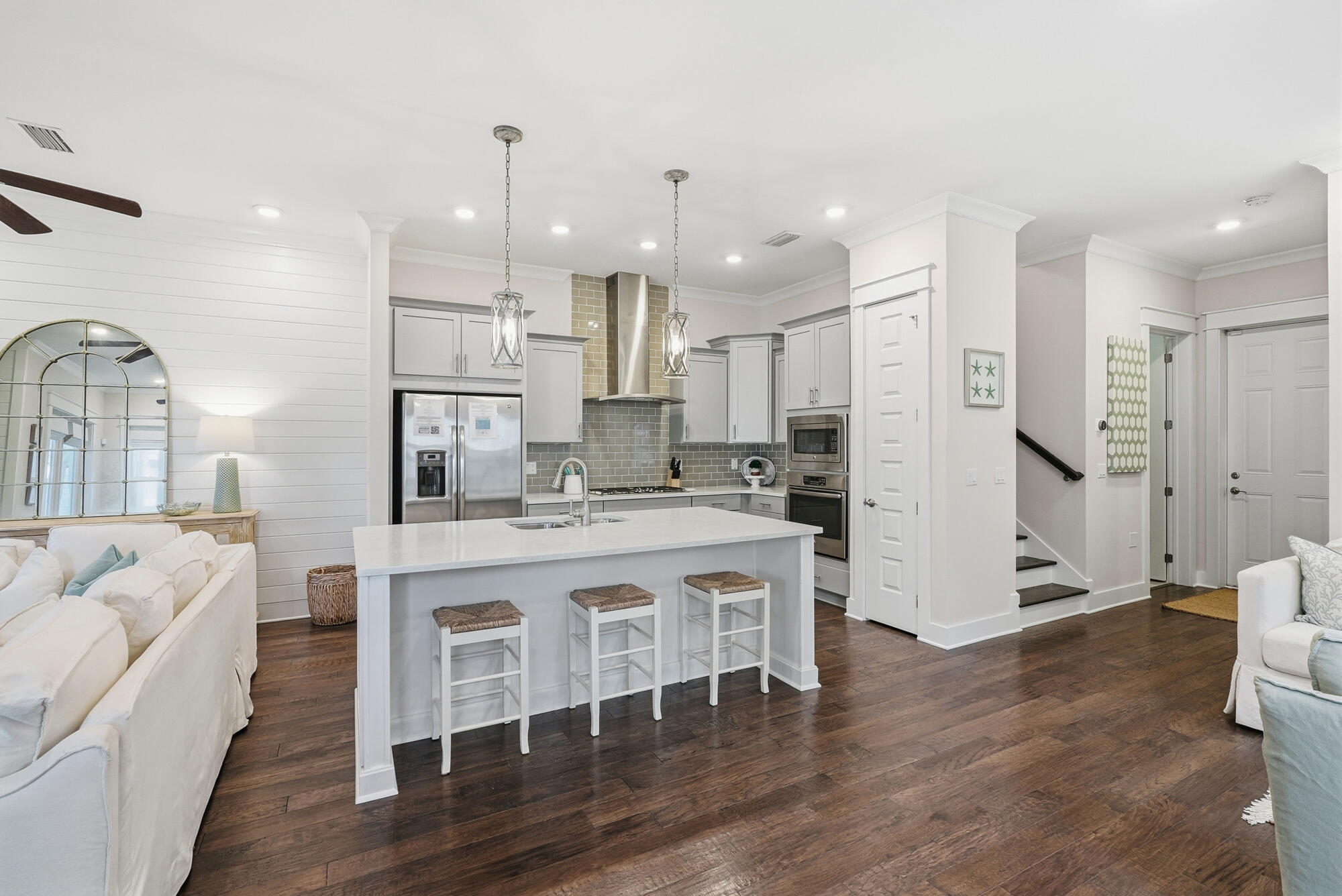 23 East York Ln Inlet Beach, Unit A Inlet Beach, FL 32461 - Photo 11 of 51 a large white kitchen with a refrigerator a sink dishwasher a fireplace and white cabinets with wooden floor