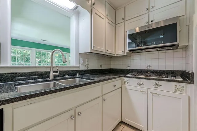 a view of an empty room with wooden floor fireplace and a window