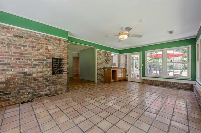 an empty room with windows and ceiling fan