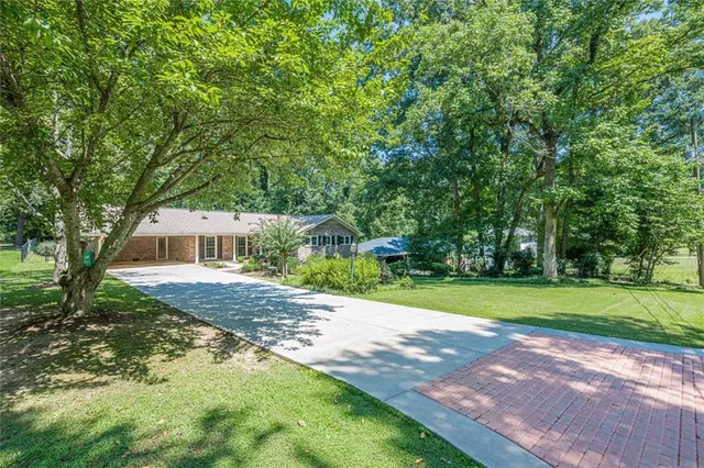 a front view of a house with a yard and trees