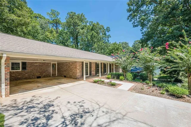 a front view of a house with a yard and trees