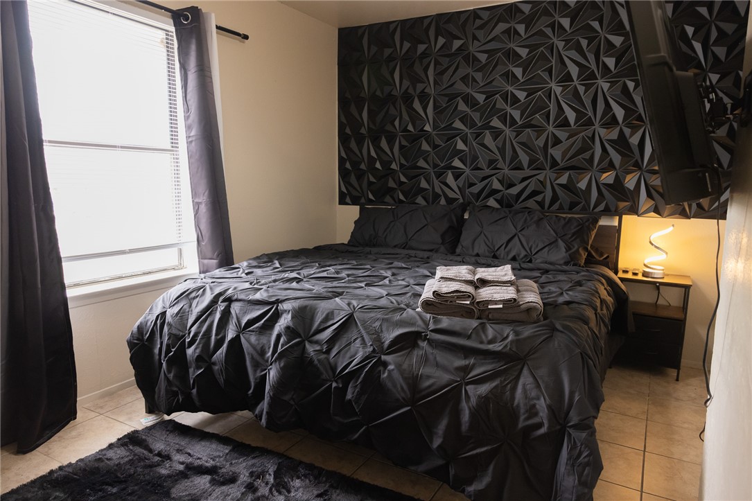 800 Navidad Street Bryan, TX 77801 - Photo 14 of 42 Bedroom with tile patterned floors and an accent wall