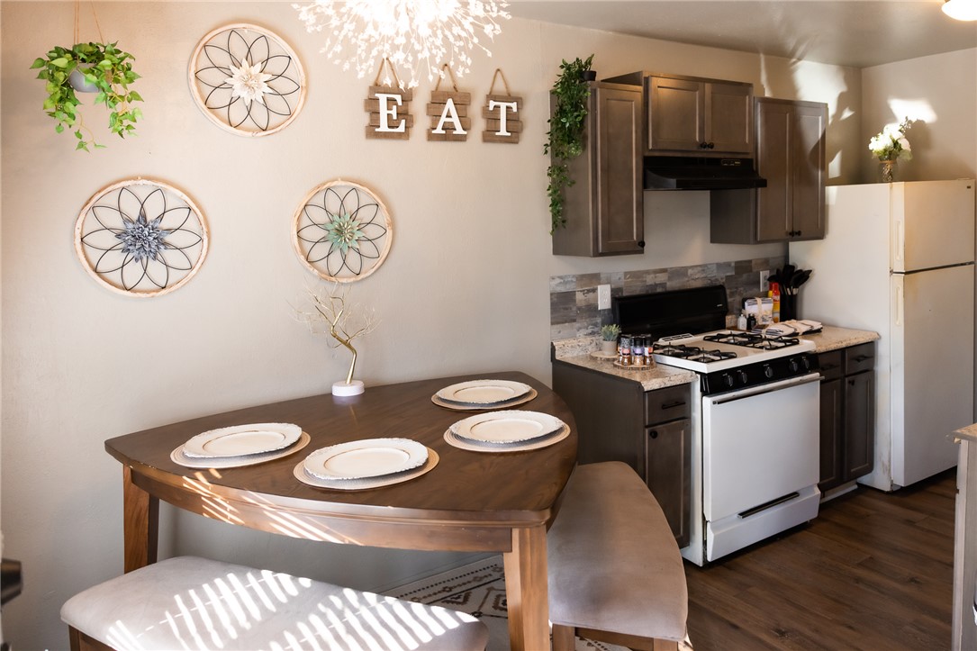 800 Navidad Street Bryan, TX 77801 - Photo 34 of 42 Kitchen with white appliances, dark brown cabinets, under cabinet range hood, decorative backsplash, and dark wood-style flooring
