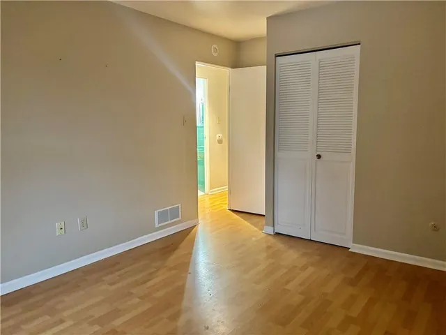a view of an empty room with wooden floor