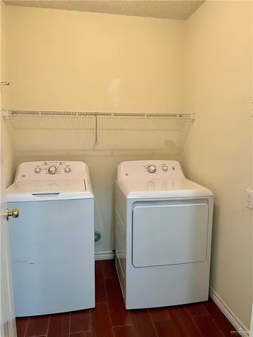 an empty room with wooden floor and fan