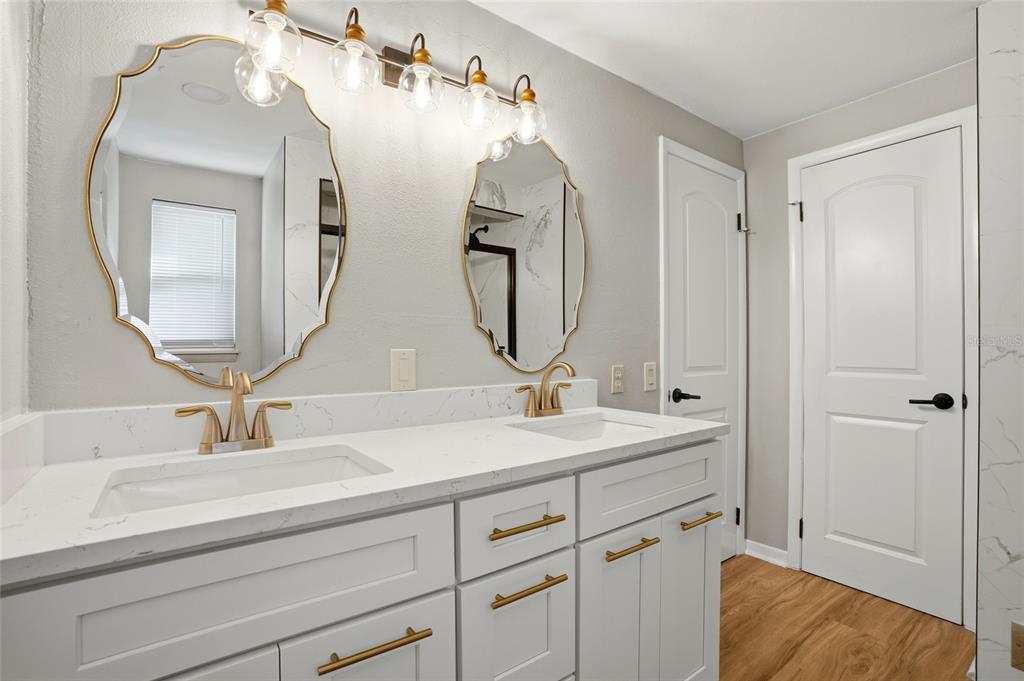 8244 125th Street Seminole, FL 33776 - Photo 18 of 32 a bathroom with a double vanity sink and a mirror