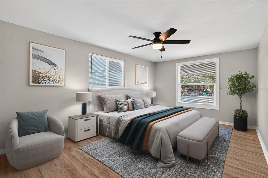 8244 125th Street Seminole, FL 33776 - Photo 19 of 32 a spacious bedroom with a bed a couch and potted plant with the outer view