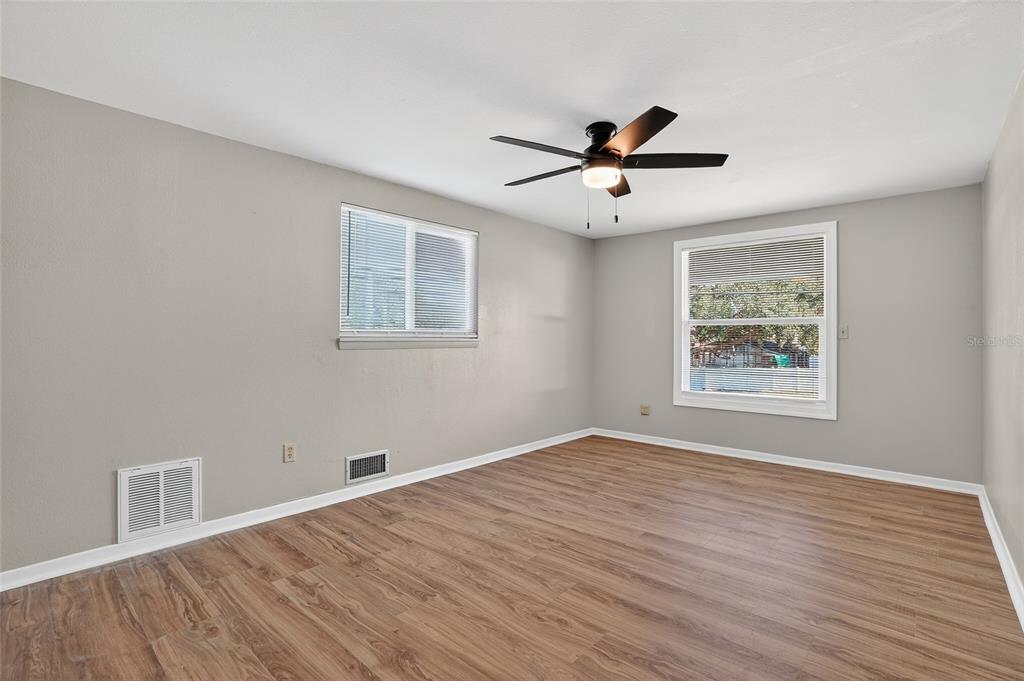 8244 125th Street Seminole, FL 33776 - Photo 20 of 32 a view of an empty room with a window and wooden floor