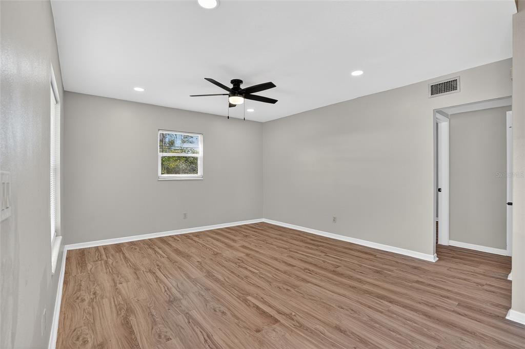 8244 125th Street Seminole, FL 33776 - Photo 4 of 32 wooden floor in an empty room with a window