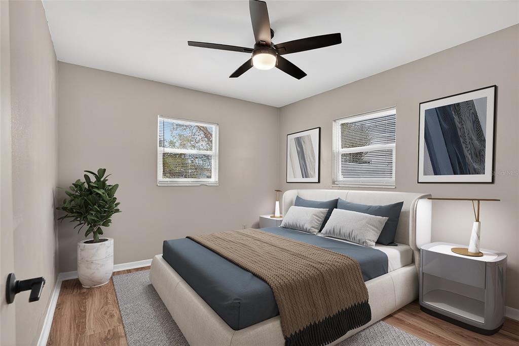 8244 125th Street Seminole, FL 33776 - Photo 10 of 32 a bedroom with a large bed and a potted plant