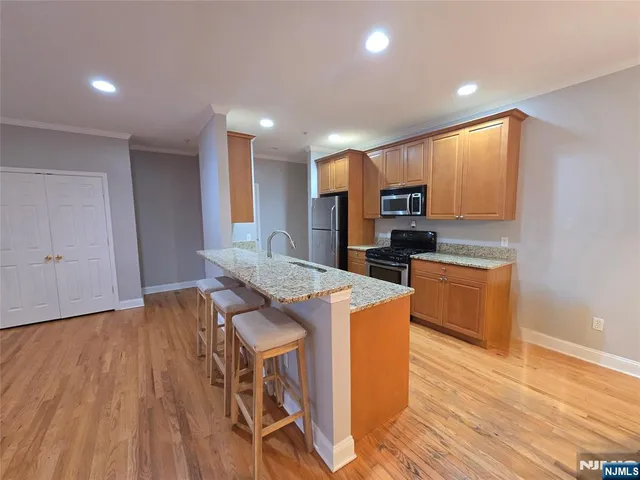 a large kitchen with stainless steel appliances granite countertop a stove a sink and a refrigerator