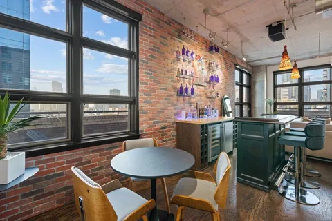 a room with wooden furniture and kitchen view