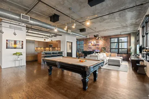 a kitchen with stainless steel appliances granite countertop a refrigerator a stove and a sink with wooden floor