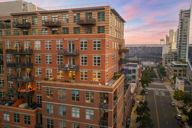 a kitchen with stainless steel appliances granite countertop a refrigerator a stove and a sink with wooden floor