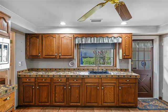a kitchen with stainless steel appliances granite countertop a stove a sink and a microwave