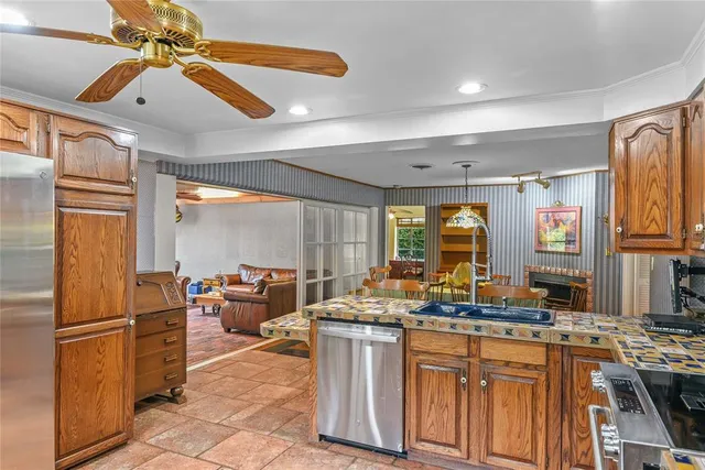 a kitchen with stainless steel appliances granite countertop a stove refrigerator and cabinets