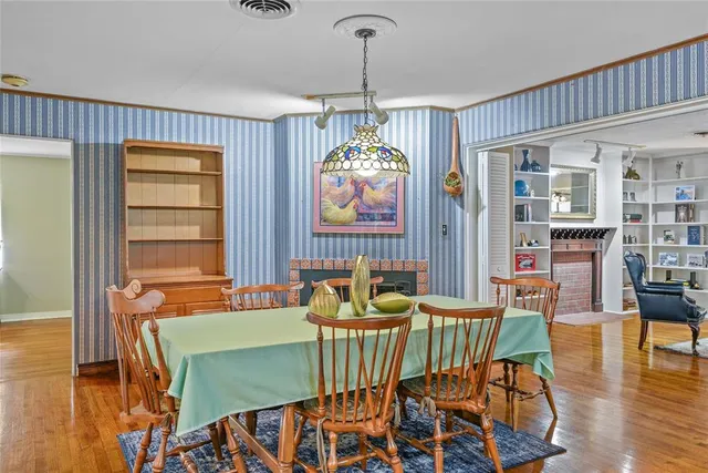 a dining room with furniture a chandelier and wooden floor