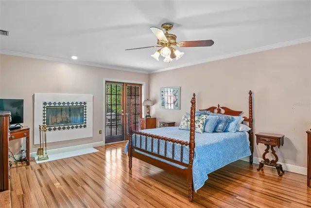 a bedroom with a large bed a flat tv screen and dresser