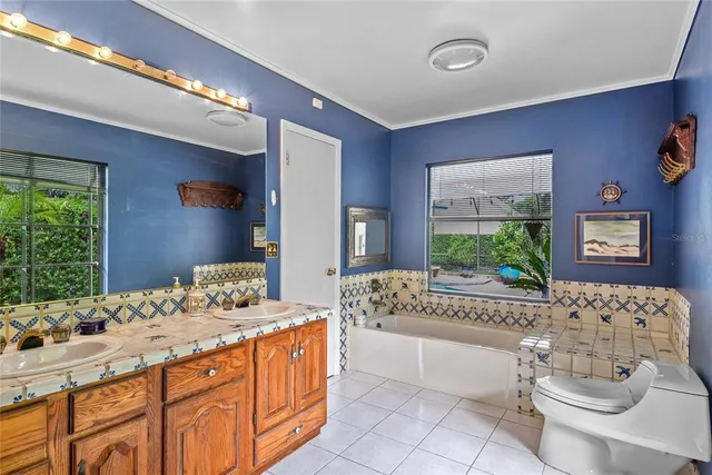 a bathroom with a granite countertop sink a toilet a mirror and window