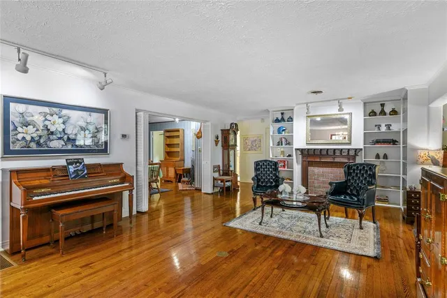 a living room with furniture and a piano next to a large window