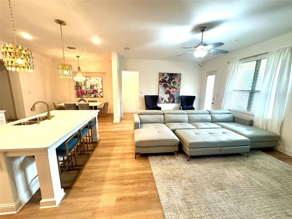 7024 Tree Stand Point Little Elm, TX 76227 - Photo 9 of 30 a living room with furniture and a chandelier