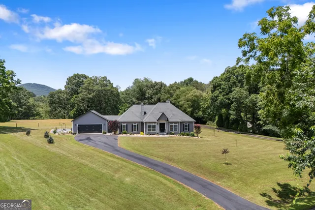 a view of house with garden space and sitting area