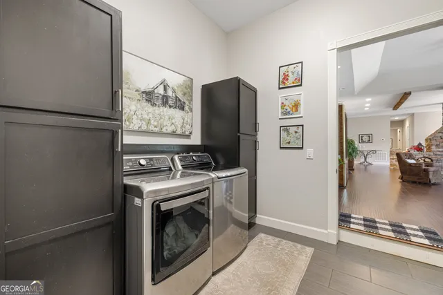 a kitchen with stainless steel appliances granite countertop a stove top oven a sink dishwasher a dining table and chairs with wooden floor