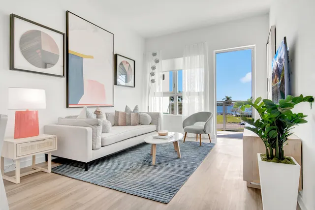 a kitchen with stainless steel appliances granite countertop a stove top oven a sink dishwasher a microwave oven and a dining table with wooden floor