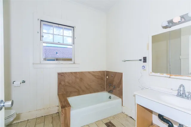 a bathroom with a tub sink and mirror