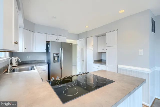 a kitchen with a refrigerator sink and cabinets
