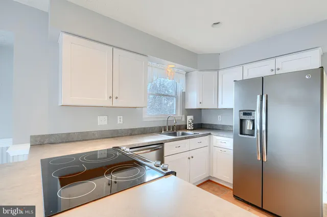 a kitchen with stainless steel appliances granite countertop a refrigerator and a stove